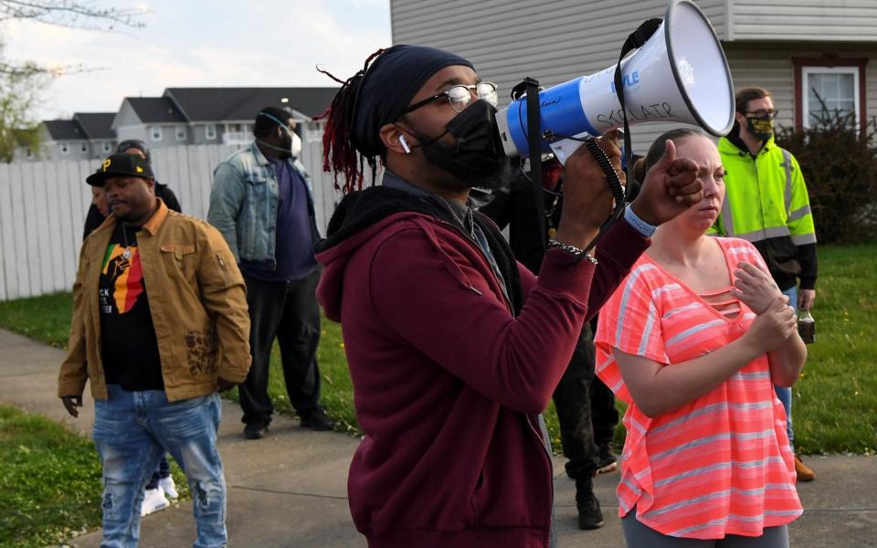 Crowds react as investigators work at the scene where Makiyah Bryant was fatally shot by a police officer in Columbus - Reuters