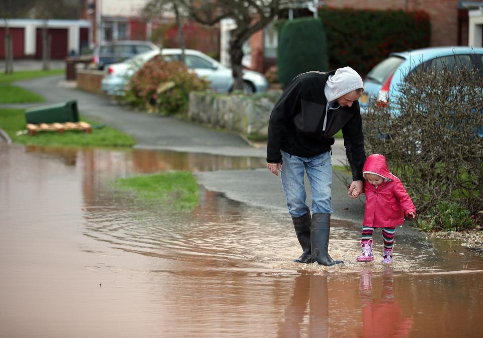 TAUNTON, UNITED KINGDOM - NOVEMBER 25: A young girl splashes through flood water in the centre of the village of Ruishton, near Taunton, on November 25, 2012 in Somerset, England. Another band of heavy rain and wind continued to bring disruption to many parts of the country today particularly in the south west which was already suffering from flooding earlier in the week. (Photo by Matt Cardy/Getty Images)