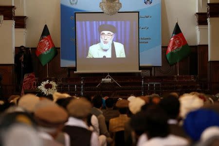 Afghans watch a screen showing the broadcast of Gulbuddin Hekmatyar during a signing ceremony with Afghan government at the presidential palace in Kabul, Afghanistan September 29, 2016. REUTERS/ Omar Sobhani