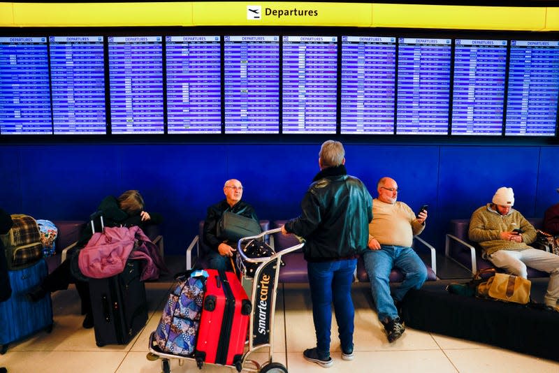 Travelers look at a departures board at Denver International Airport showing canceled and delayed flights during a winter storm on February 22, 2023. 