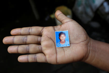 A relative holds a picture of detained Rohingya fisherman Mohammed Enus, 18, in Sittwe in the state of Rakhine, Myanmar March 2, 2017. REUTERS/Soe Zeya Tun