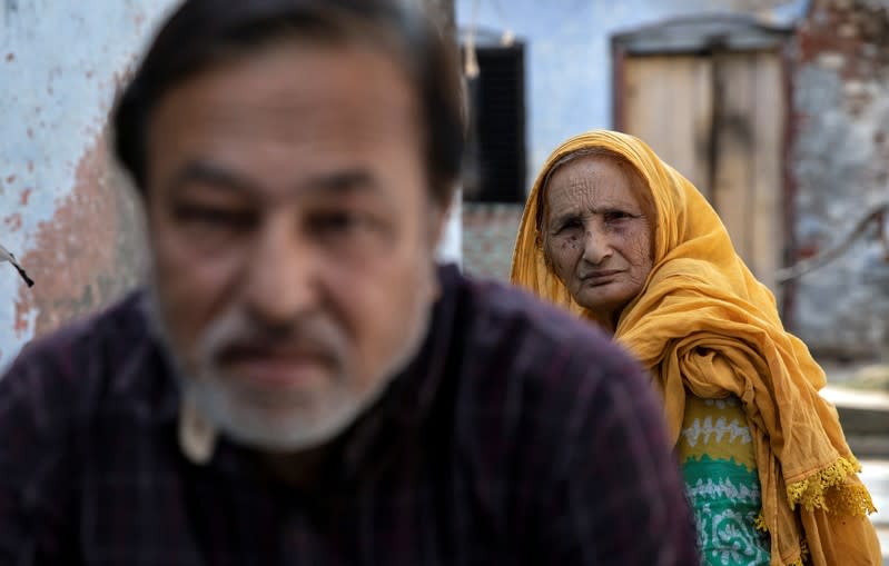 Zaibunissa, whose husband was killed during riots following the demolition of Babri Masjid, sits with her son Mohammed Shahid outside their house in Ayodhya