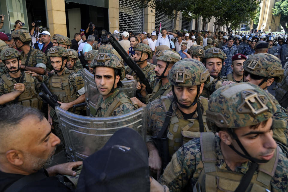 Soldiers scuffle with retired army members as they try to enter to the parliament building while the legislature was in session discussing the 2022 budget, during a protest in downtown Beirut, Lebanon, Monday, Sept. 26, 2022. The protesters demanded an increase in their monthly retirement pay, decimated during the economic meltdown. (AP Photo/Bilal Hussein)