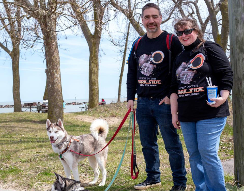 Rick, left, and Carmella Holt walk their Siberian huskies, Hallie and Rhyza, Monday at East Harbor State Park in Ohio. The couple drove seven hours from New Freedom, Pennsylvania, to view the eclipse.