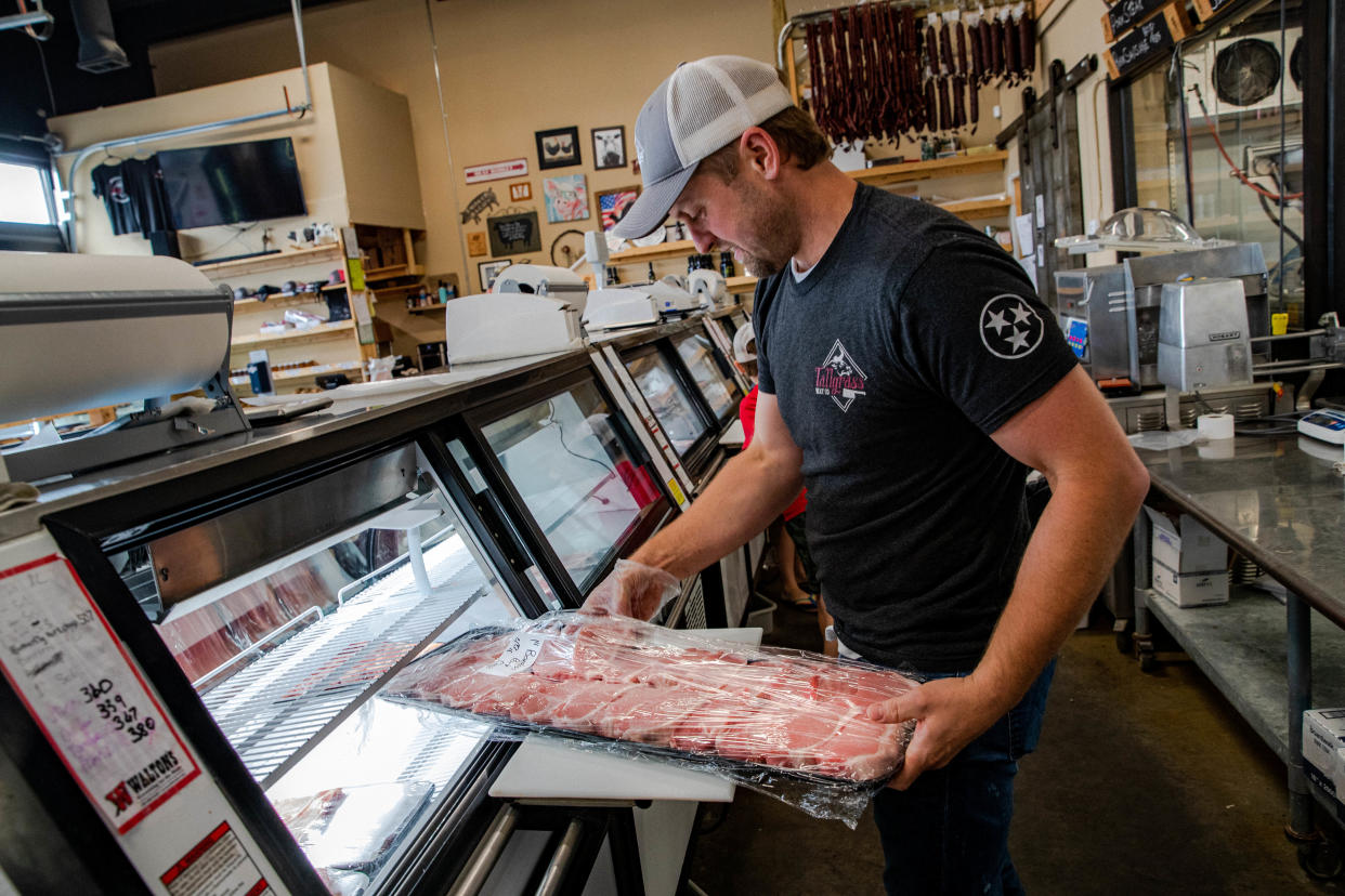 Tallgrass Meat Co. owner Casey Weber removes a rack of pork chops to package and sell to a customer at the local meat shop in Columbia, Tenn. on Monday July 18, 2022.