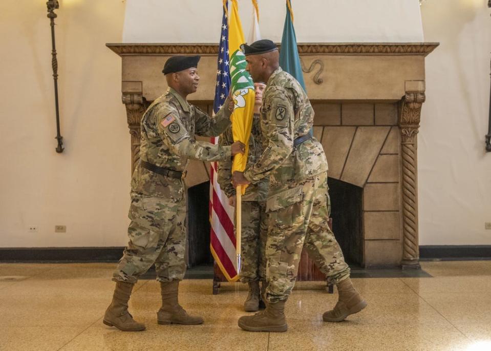 Then Maj. Gen. Gary M. Brito, right, commanding general of the Maneuver Center of Excellence, passes the U.S. Army Armor School guidon to incoming commandant Brig. Gen. Kevin Admiral during a ceremony Sept. 27, 2019.