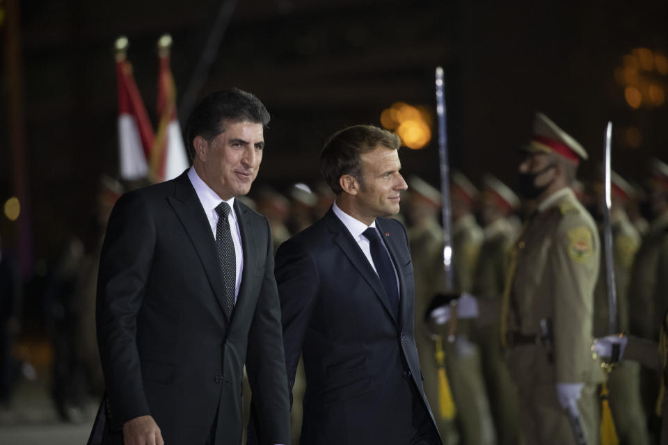 Kurdish President Nechirvan Barzani, left, welcomes French President Emmanuel Macron upon his arrival to Irbil airport, Iraq, early Sunday, Aug. 29, 2021. (AP Photo/Hadi Mizban)