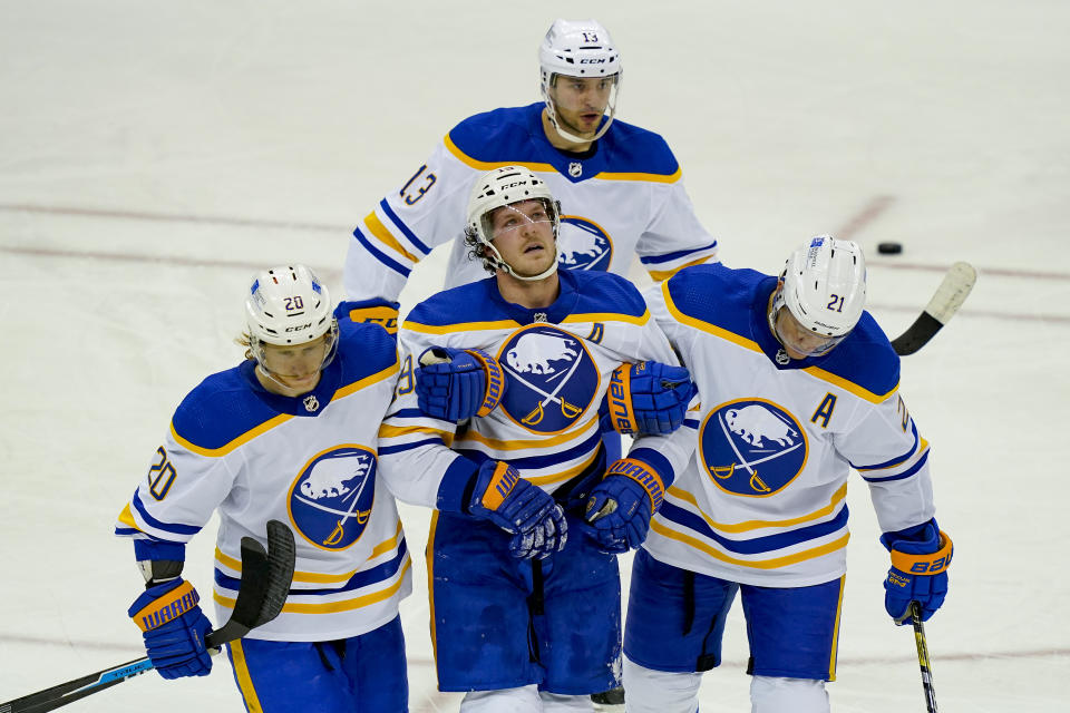 Buffalo Sabres defenseman Jake McCabe (19) reacts after taking an injury and being helped off the ice during the third period of an NHL hockey game against the New Jersey Devils, Saturday, Feb. 20, 2021, in Newark, N.J. (AP Photo/John Minchillo)