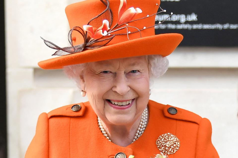 <h1 class="title">a close-up of queen elizabeth II wearing an orange hat and coat at the science museum in england</h1><cite class="credit">Getty Images</cite>