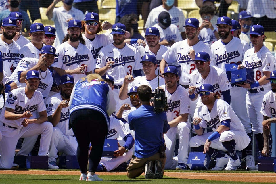 Members of the Los Angeles Dodgers pose for photos with their 2020 World Series Championship ring before a baseball game against the Washington Nationals, Friday, April 9, 2021, in Los Angeles. (AP Photo/Marcio Jose Sanchez)