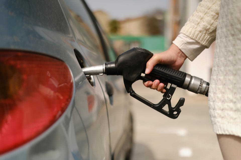 Person refueling a car at a gas station