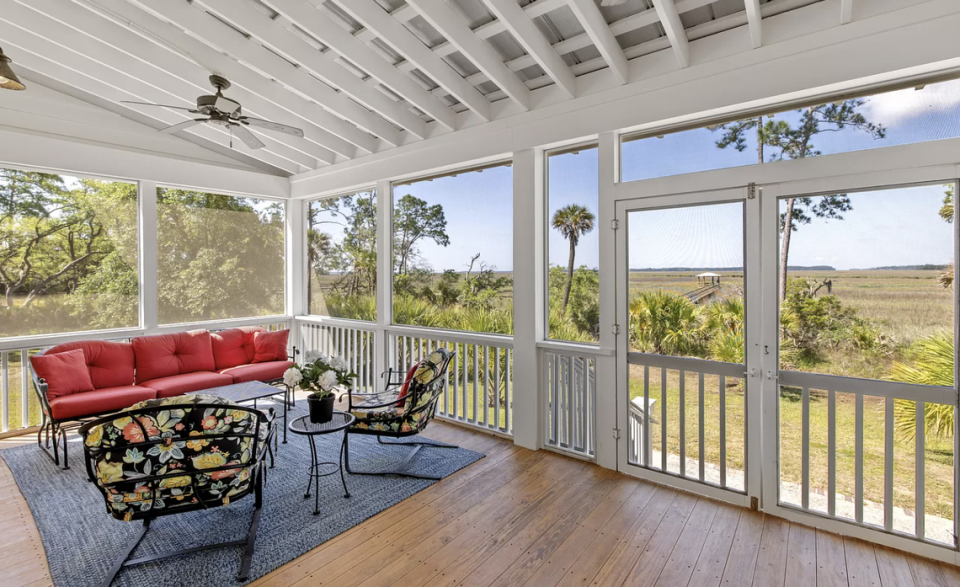 A screened porch overlooks the creek and surrounding maritime forest. 