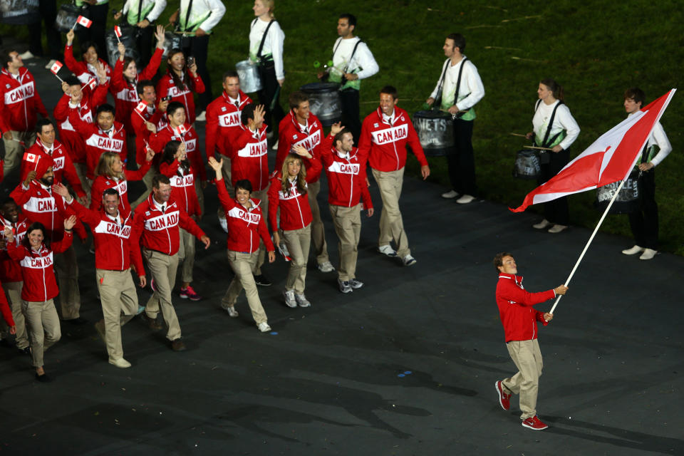 LONDON, ENGLAND - JULY 27: Simon Whitfield of the Canada Olympic triathlon team carries his country's flag during the Opening Ceremony of the London 2012 Olympic Games at the Olympic Stadium on July 27, 2012 in London, England. (Photo by Paul Gilham/Getty Images)