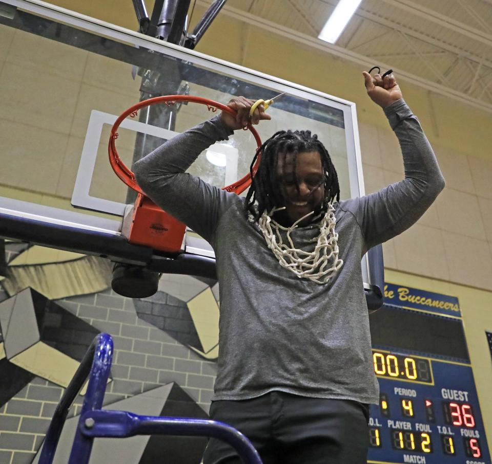 Mainland head coach Joe Giddens cuts down the net and wears it after the Bucs beat Rickards in the Region 1-5A finals Friday, Feb. 23, 2024 at Mainland High School.