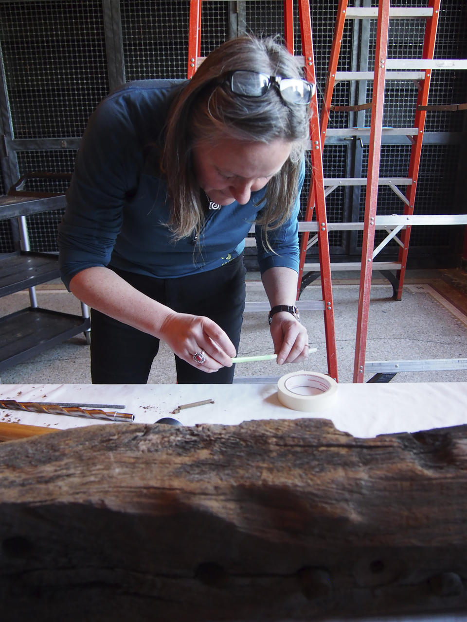 In this 2018 photo provided by the Pilgrim Hall Museum, Aoife Daly, Associate Professor, Saxo Institute, University of Copenhagen, extracts a core from an age-hardened Sparrow-hawk timber for analysis. The timbers were sampled in 2018 and analyzed over the course of several years. (Marie Pelletier/Pilgrim Hall Museum photo via AP)