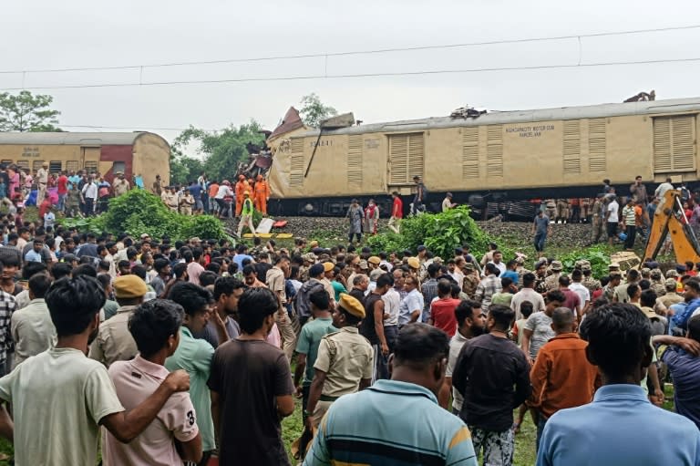 People look on at the site of a collision between an express passenger train and a goods train in India's West Bangal state (Diptendu DUTTA)