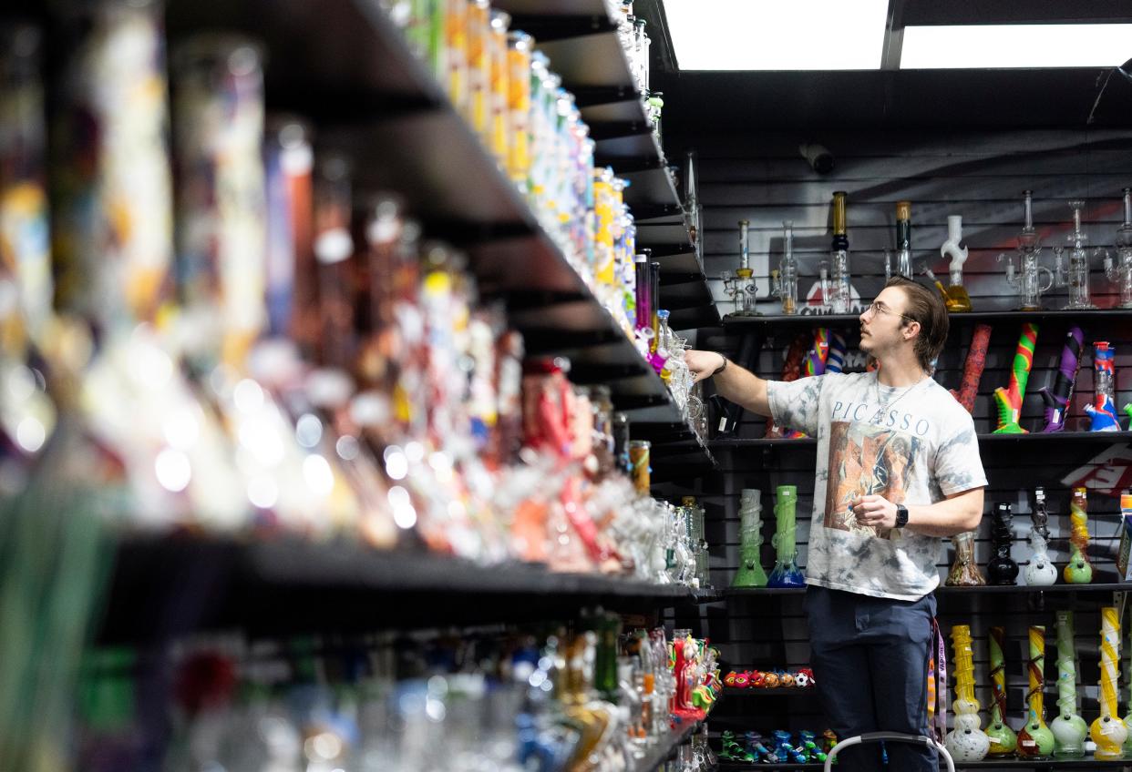 Sam Sabo, an employee at Hippie Hut, prices Water pipes during his shift. He said he wasn't surprised residents who lived near the shop on the corner of High Street and West 10th Avenue overwhelmingly supported legalized marijuana.