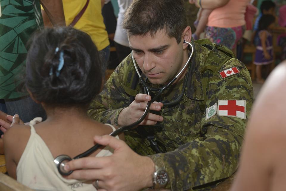 Captain Sakanovic examines a child's breathing at Dona Victoria Cortes Dais Memorial School in Pontevedra