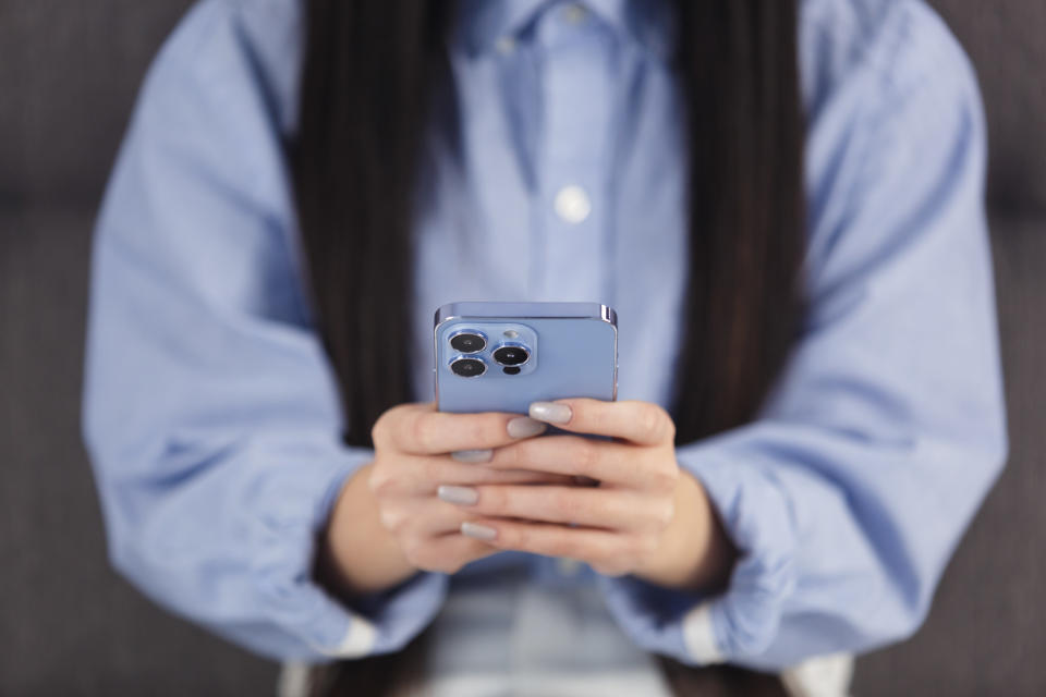 Young Vietnamese female person using modern mobile phone