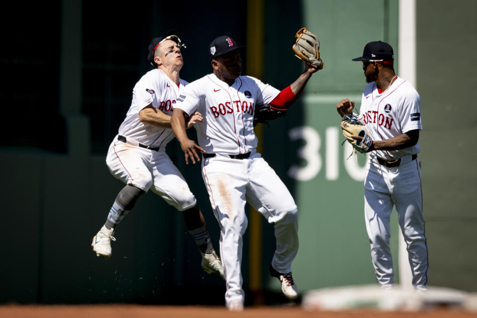 Tyler O'Neill, left, required eight stitches after a violent collision caused his head to snap back and left him and Rafael Devers sprawled on the the outfield turf at Fenway Park. (Maddie Malhotra/Boston Red Sox/Getty Images)