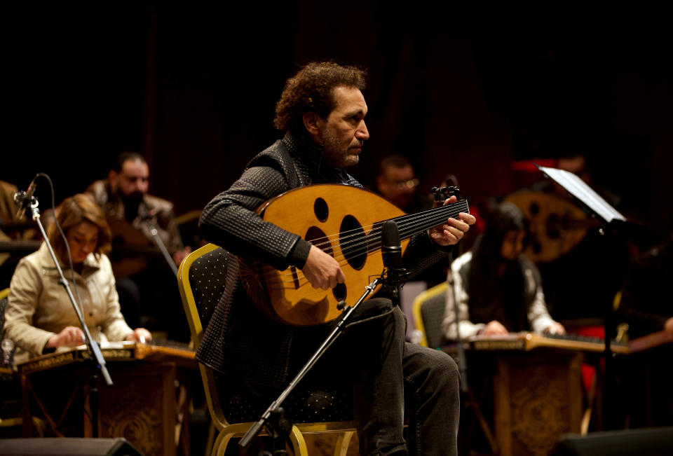 Iraqi virtuoso oud player Naseer Shamma performs with an orchestra, at the Iraqi National Theater in Baghdad, Iraq, Friday, Jan. 21, 2022. War kept him away from his beloved homeland for decades. Now Shamma has returned to Iraq with a series of concerts and projects he hopes will support education, culture and the arts in the conflict-scarred nation. (AP Photo/Hadi Mizban)