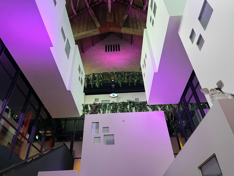 Modern walls with purple-tinted lighting and giant, peaked ceiling