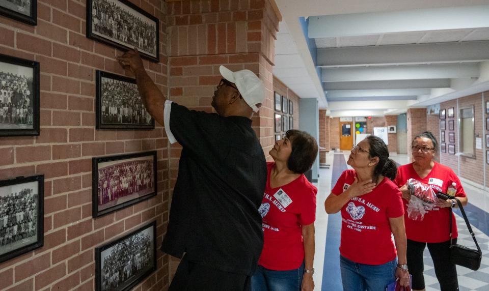 Johnston High School Class of 1973 graduates, from left, Steven Lewis, Janie Ruiz, Andrea Hagan and Barbara Escamilla look at their class photo, displayed on the walls of the former Johnston High.