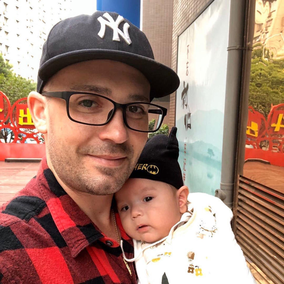 IMAGE: Christopher Suzanne holding his infant son in China.