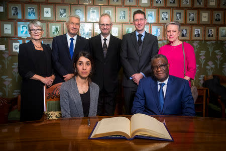 Nadia Murad and Denis Mukwege together with the Norwegian Nobel Peace Prize committee, Anne Enger, Thorbjorn Jagland, Henrik Syse, Asle Toje and Berit Reiss-Andersen, pose for a photograph after a news conference with the 2018 Nobel Laureates at the Nobel Institute in Olso, Norway December 9, 2018. Heiko Junge/NTB Scanpix/via REUTERS