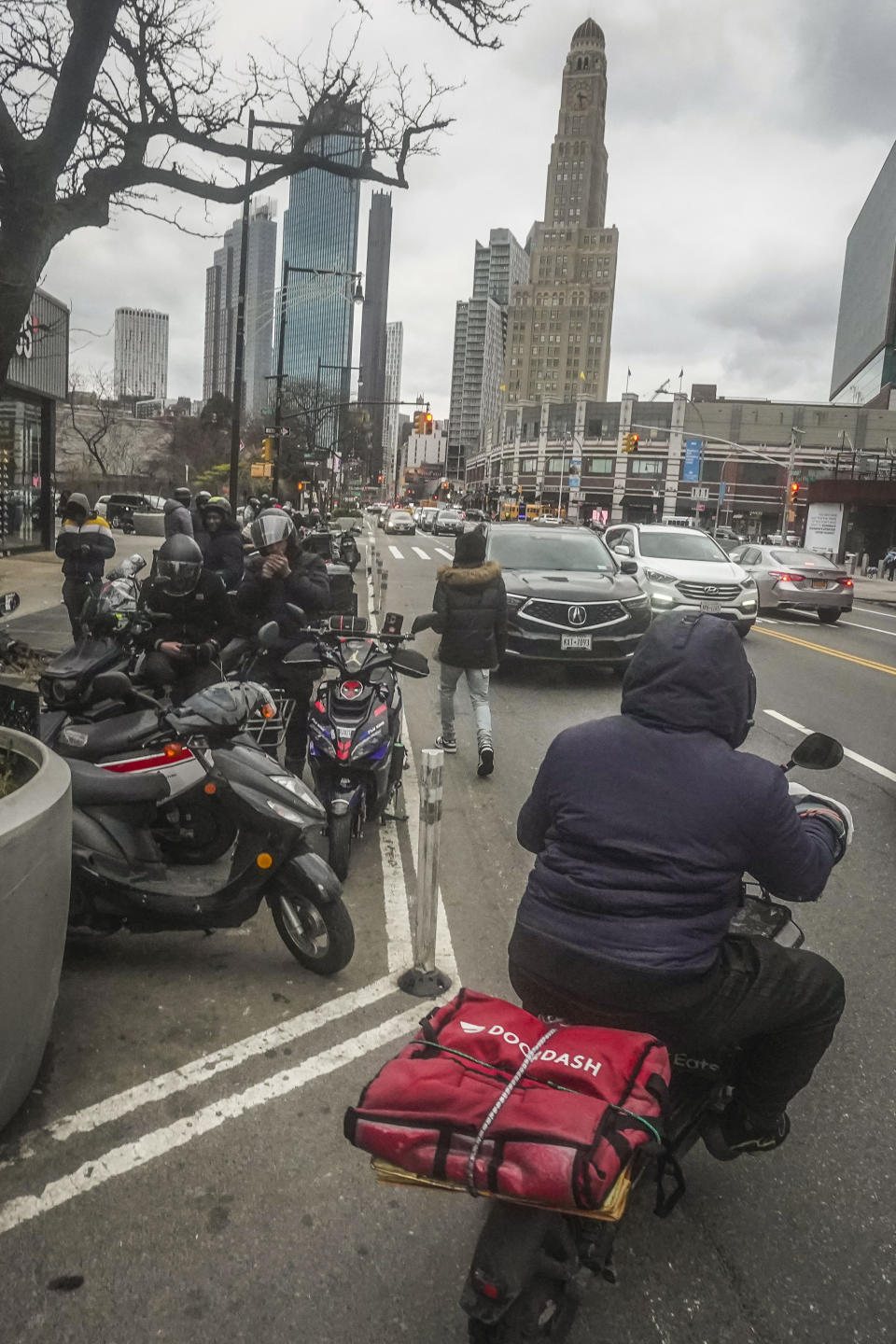 Food delivery workers gather for pickups outside fast-food restaurants on Brooklyn's Flatbush Avenue, Monday, Jan. 29, 2024, in New York. Recent city ordinances in New York and Seattle have increased minimum wage protections for app-based food delivery workers. (AP Photo/Bebeto Matthews)