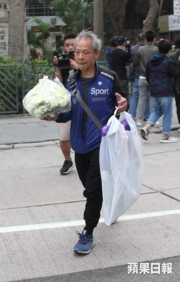 同行的男親友手拿鮮花，用袋子裝着的藍潔瑛遺照