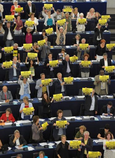 Members of the European parliament hold up placards reading "Hello democracy, goodbye ACTA" as they vote to throw out threw out the controversial global pact to battle counterfeiting and online piracy, quashing any EU ratification and possibly killing it for good