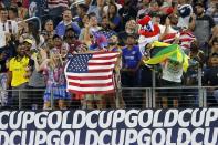 Fans wave American and Jamaican flags during team warmups before a 2021 CONCACAF Gold Cup quarterfinals soccer match, Sunday, July 25, 2021, in Arlington, Texas. (AP Photo/Brandon Wade)