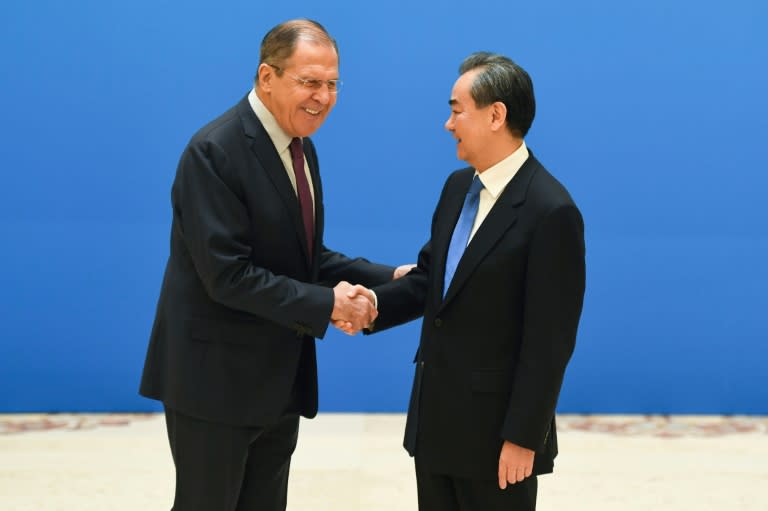 Russian Foreign Minister Sergei Lavrov (L) shakes hands with Chinese Foreign Minister Wang Yi in Beijing in April 2018 -- but the two nations no longer work in strict tandem at the United Nations