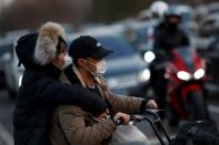 People wear face masks in a street in Beijing as the country is hit by an outbreak of the novel coronavirus