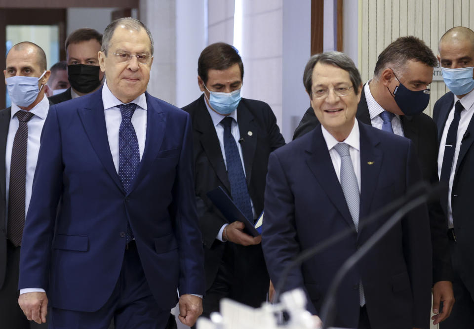 In this photo released by the Russian Foreign Ministry Press Service, Russian Foreign Minister Sergey Lavrov, left, and Cypriot President Nicos Anastasiades arrive to attend a joint news conference following their talks at the Presidential Palace in Nicosia, Cyprus, Tuesday, Sept. 8, 2020. (Russian Foreign Ministry Press Service via AP)