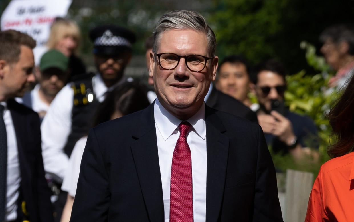 Sir Keir wears a red tie as he arrives at a polling station