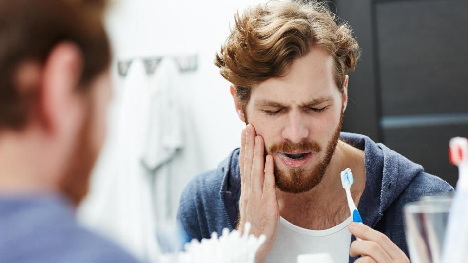 young guy with hurt tooth