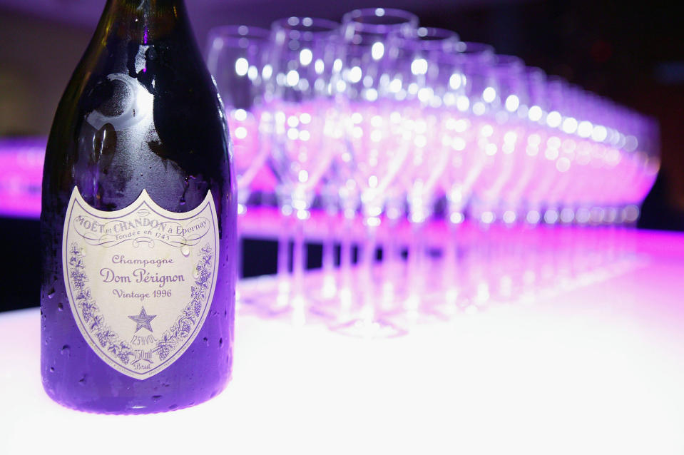 A bottle of Dom Pérignon with a row of glasses behind it