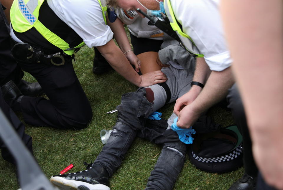 SENSITIVE MATERIAL. THIS IMAGE MAY OFFEND OR DISTURB Police officers give aid to a girl who was stabbed in the leg during a scuffle at a demonstration to mark the informal cannabis holiday, 4/20, in Hyde Park, London, Britain, April 20, 2021. REUTERS/Tom Nicholson