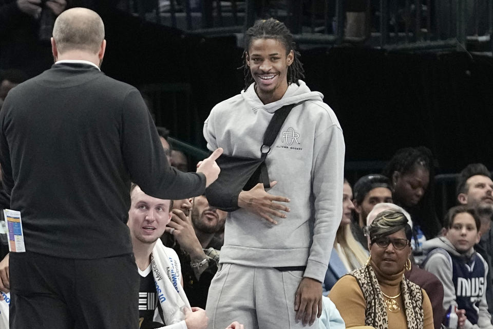 Injured Memphis Grizzlies guard Ja Morant stands and watches from the bench during the first half of an NBA basketball game against the Dallas Mavericks in Dallas, Tuesday, Jan. 9, 2024. (AP Photo/LM Otero)