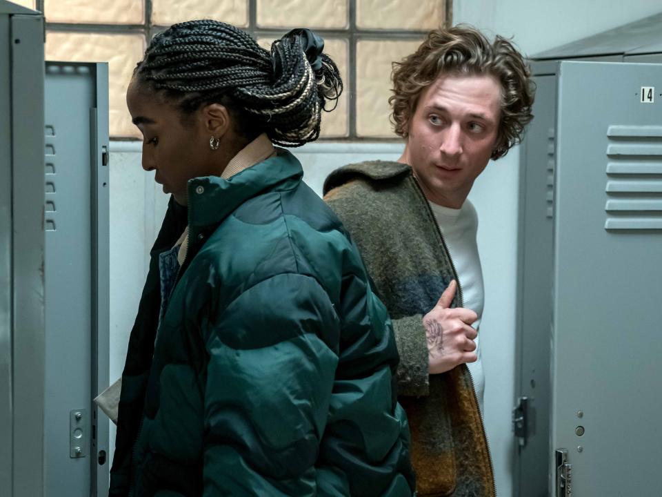 ayo edebiri and jeremy allen white in the bear, standing not facing each other in a locker room