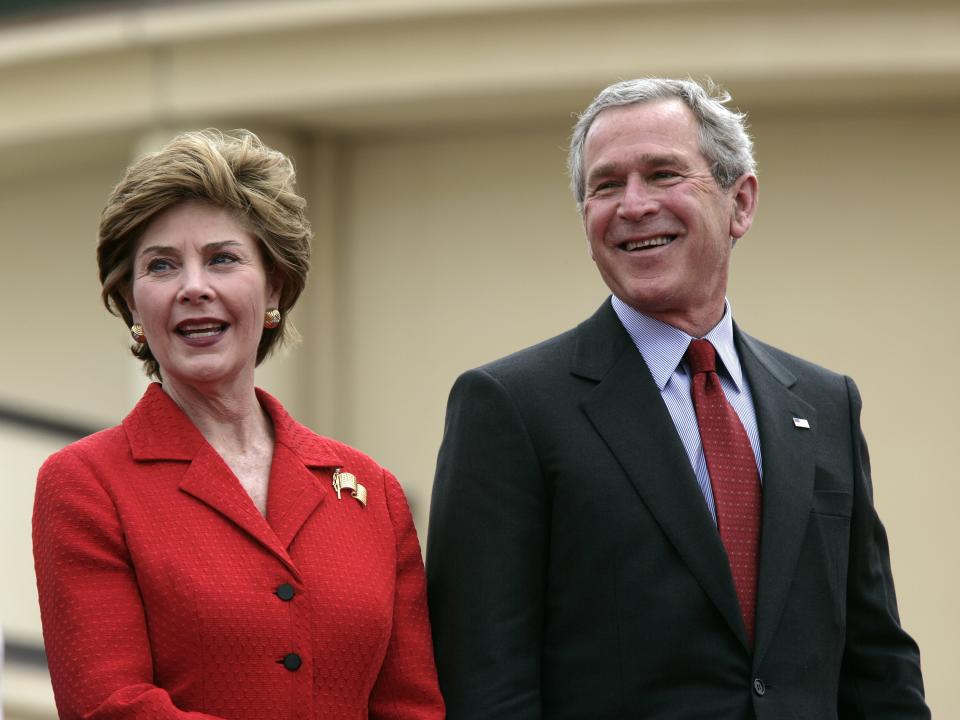 George W. Bush and Laura Bush wear matching red outfits.