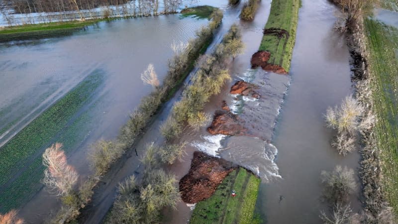 Masses of water flow through the dyke opening on the River Helme onto the surrounding areas. Heiko Rebsch/dpa