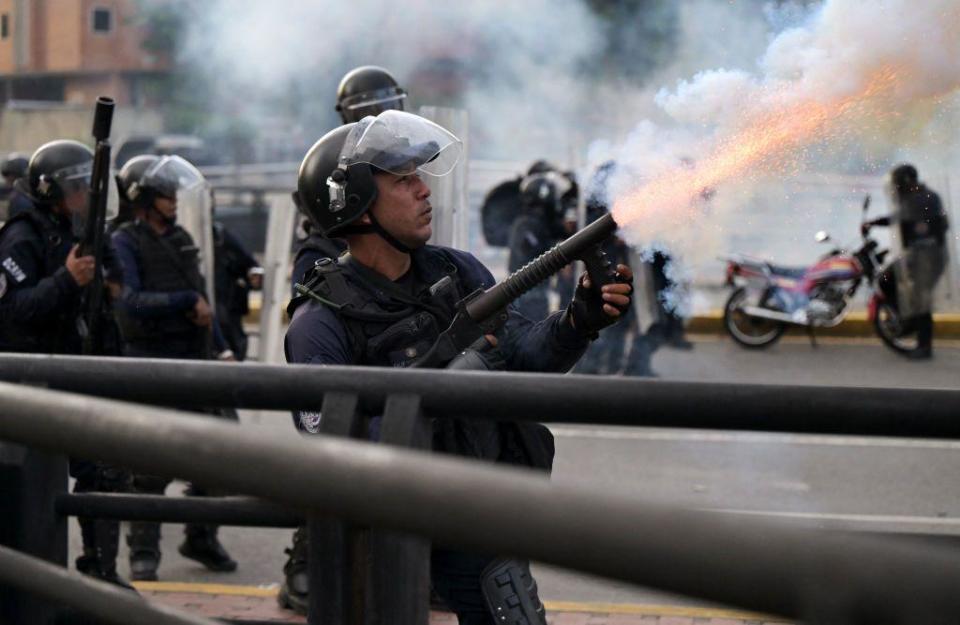 Un policía disparando gases