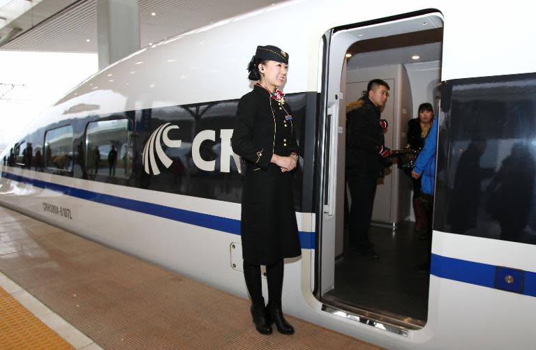 A file photo shows a conductor standing beside a new Chinese high speed train in Zhengzhou, Henan province, December 2012