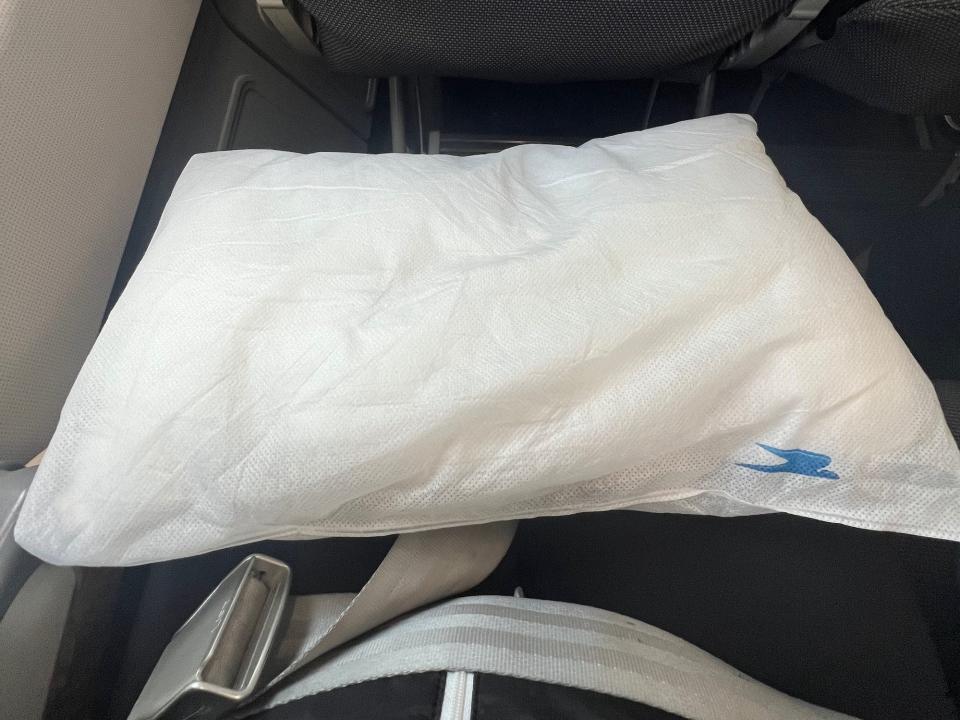 The white pillow with the Aerolineas logo on my lap.