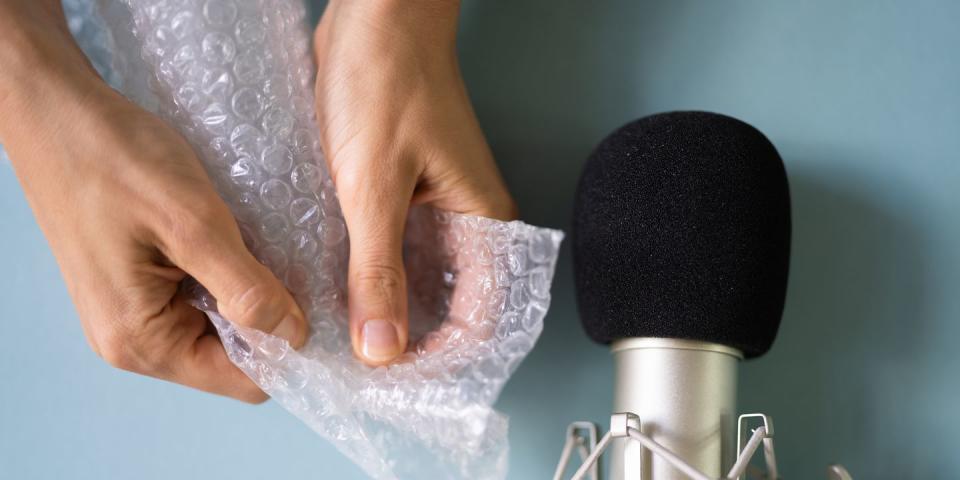 microphone next to a pair of hands crinkling a sheet of bubble wrap