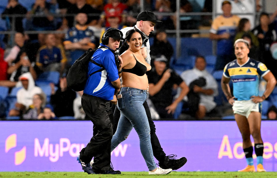 The pitch invader, pictured here being taken from the field by security guards.