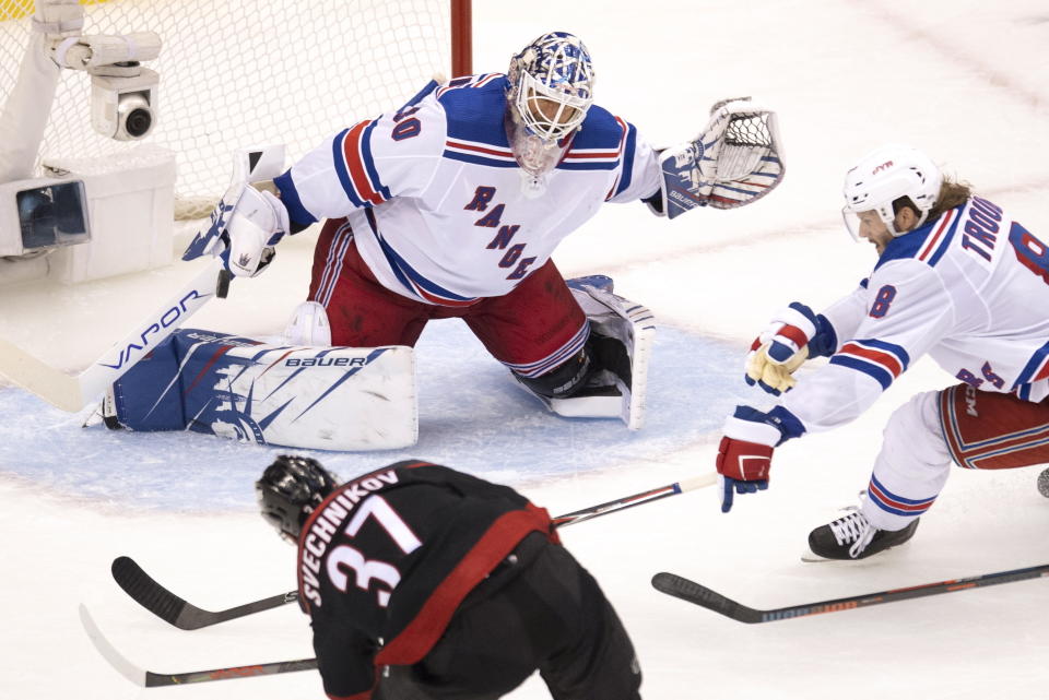 Carolina Hurricanes right wing Andrei Svechnikov (37) scores his third goal of the game past New York Rangers goaltender Henrik Lundqvist (30) as defenseman Jacob Trouba (8) tries to help out durng the third period of an NHL Stanley Cup playoff hockey game in Toronto, Monday, Aug. 3, 2020. (Frank Gunn/The Canadian Press via AP)